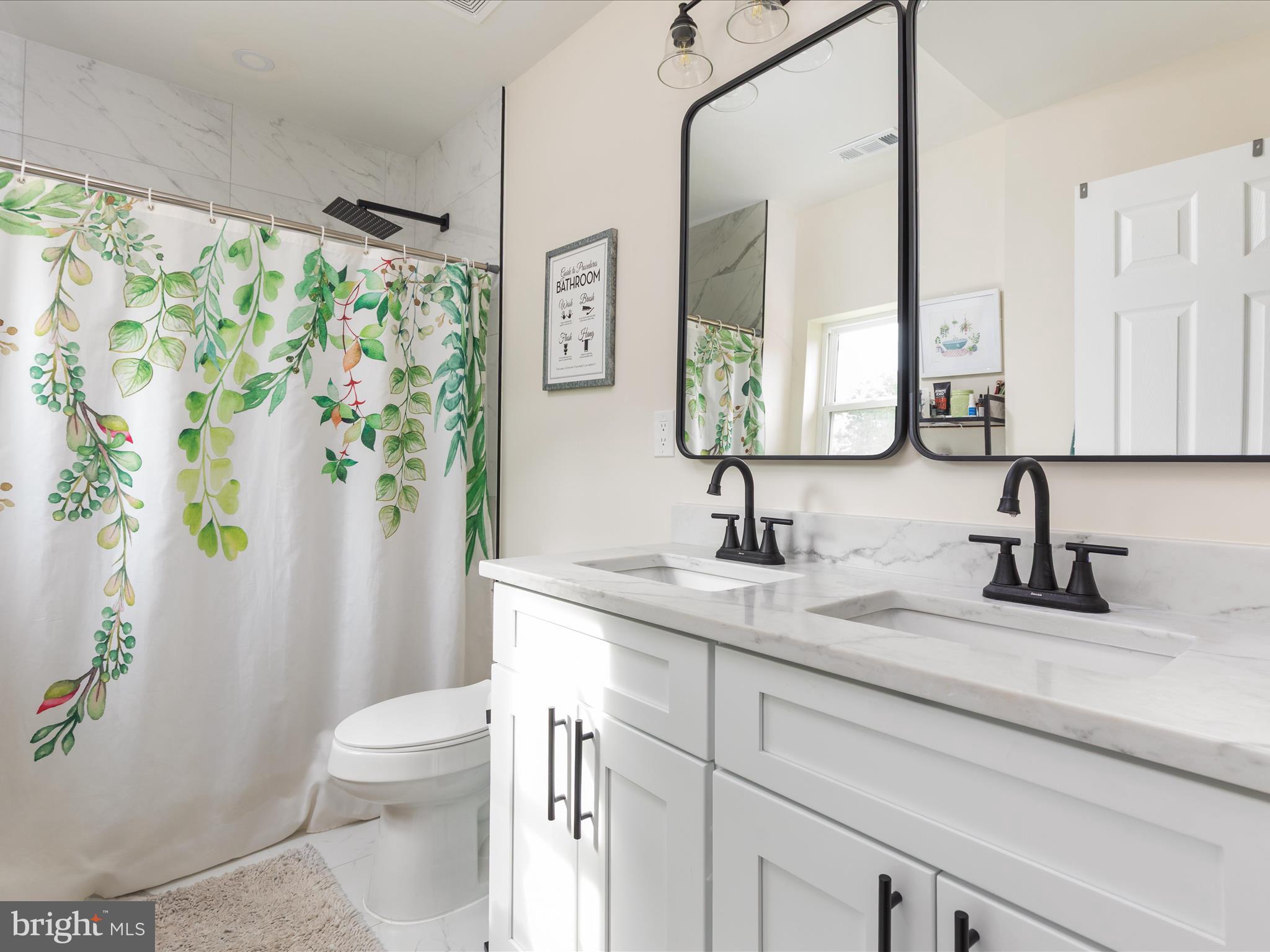 790 McDonald Road Winchester, VA 22602 - Photo 13 of 36 a bathroom with a granite countertop sink a toilet a mirror a vanity and shower