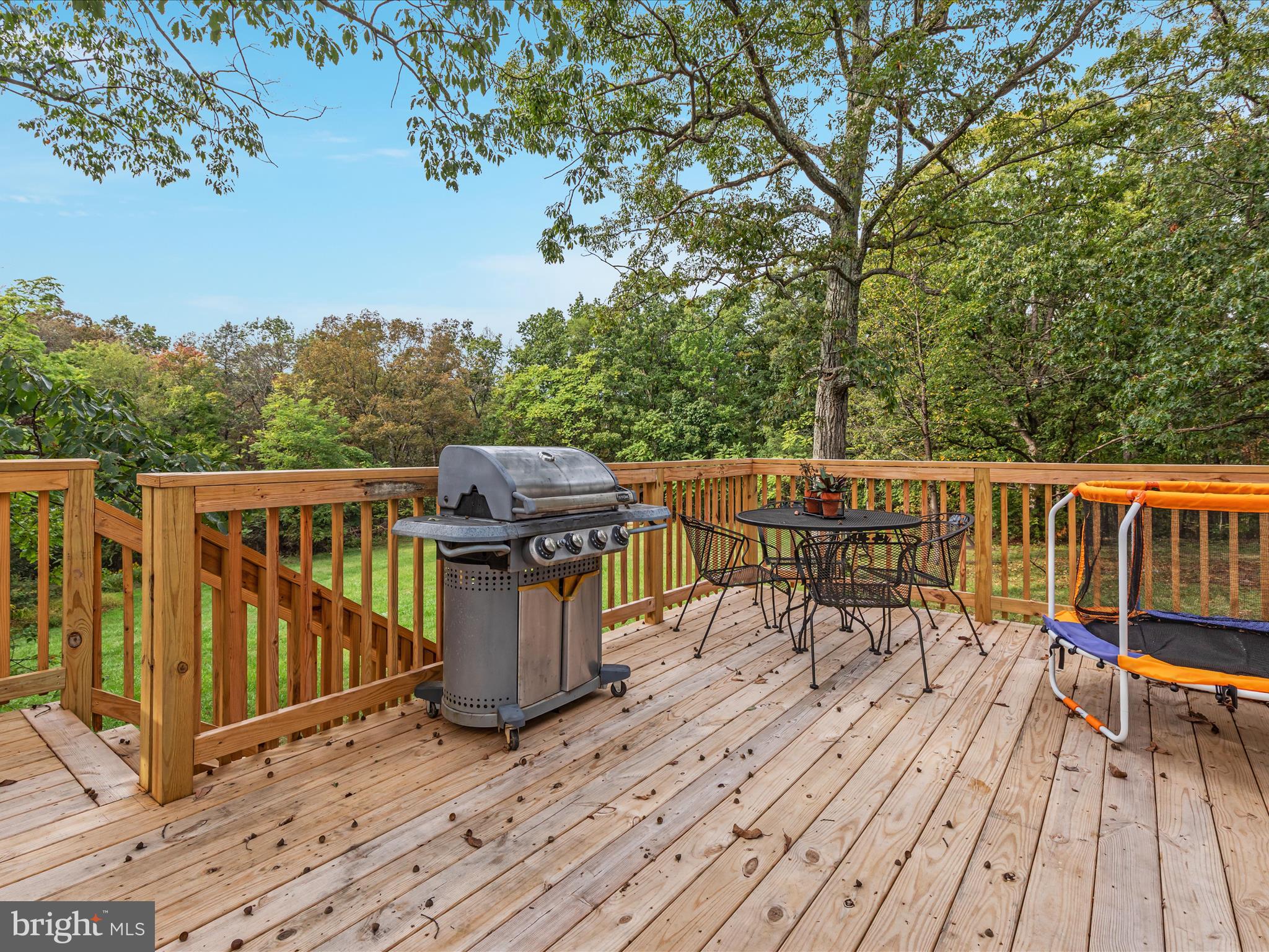 790 McDonald Road Winchester, VA 22602 - Photo 19 of 36 a view of a roof deck with table and chairs a barbeque with wooden floor and fence