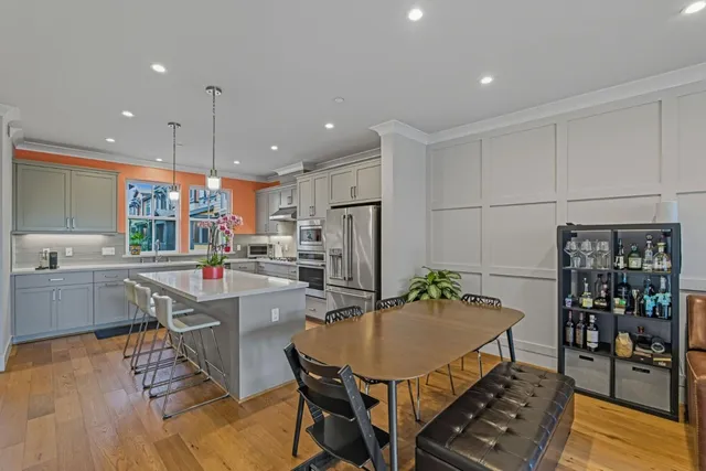 a kitchen with stainless steel appliances granite countertop a sink a stove and a wooden floors