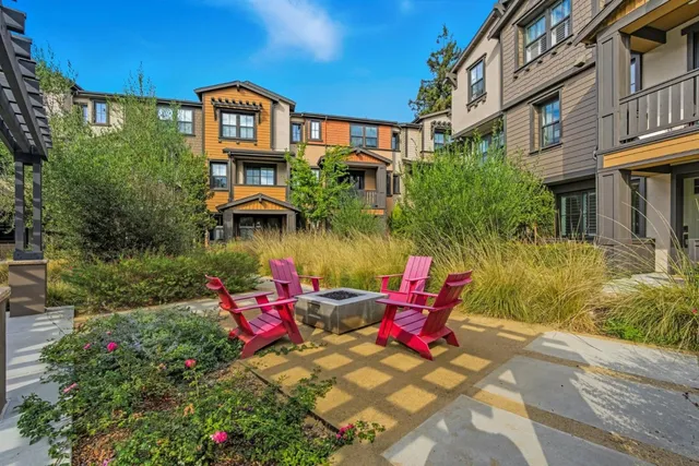 a view of a brick building with many windows and flower plants