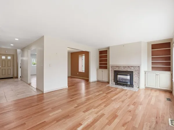 a view of a livingroom with wooden floor and a fireplace