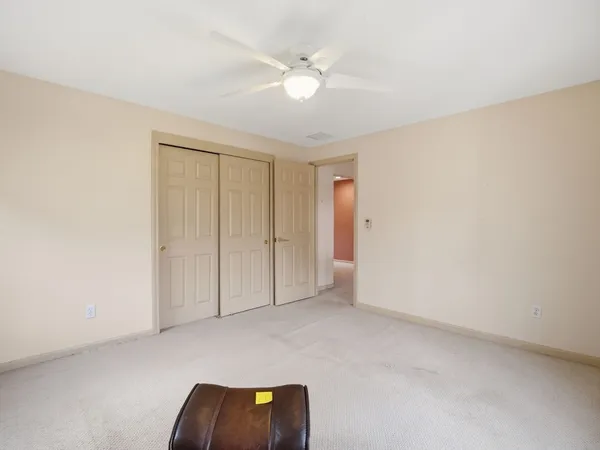 an empty room with closet and ceiling fan
