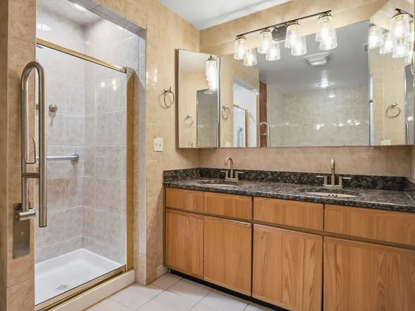 a bathroom with a granite countertop shower a sink and a mirror