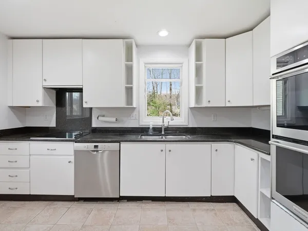 a kitchen with granite countertop white cabinets white stainless steel appliances and sink