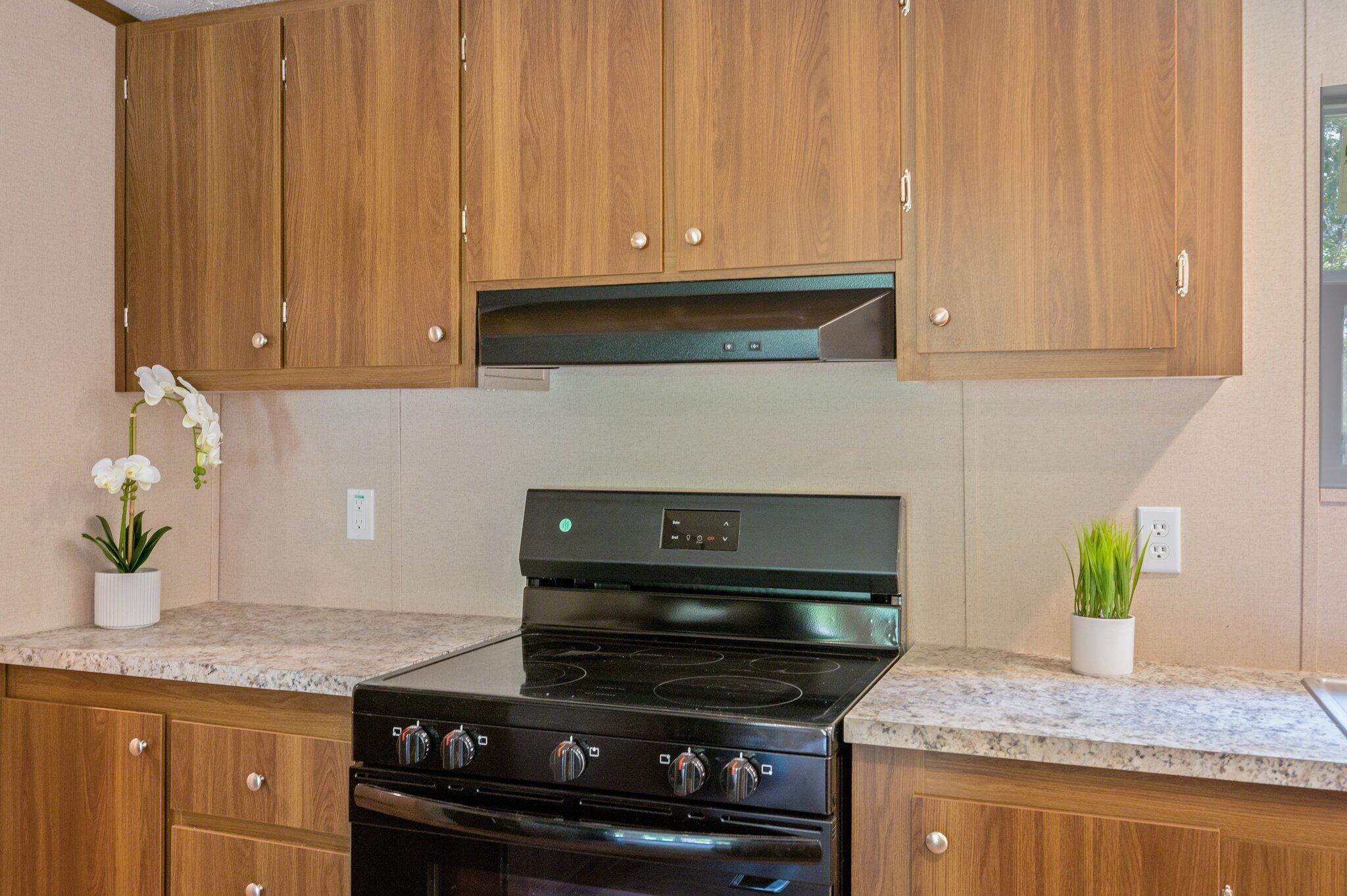 5227 Richardson Road Crestview, FL 32539 - Photo 16 of 44 a kitchen with granite countertop a stove top oven cabinetry a chimney and granite counter space