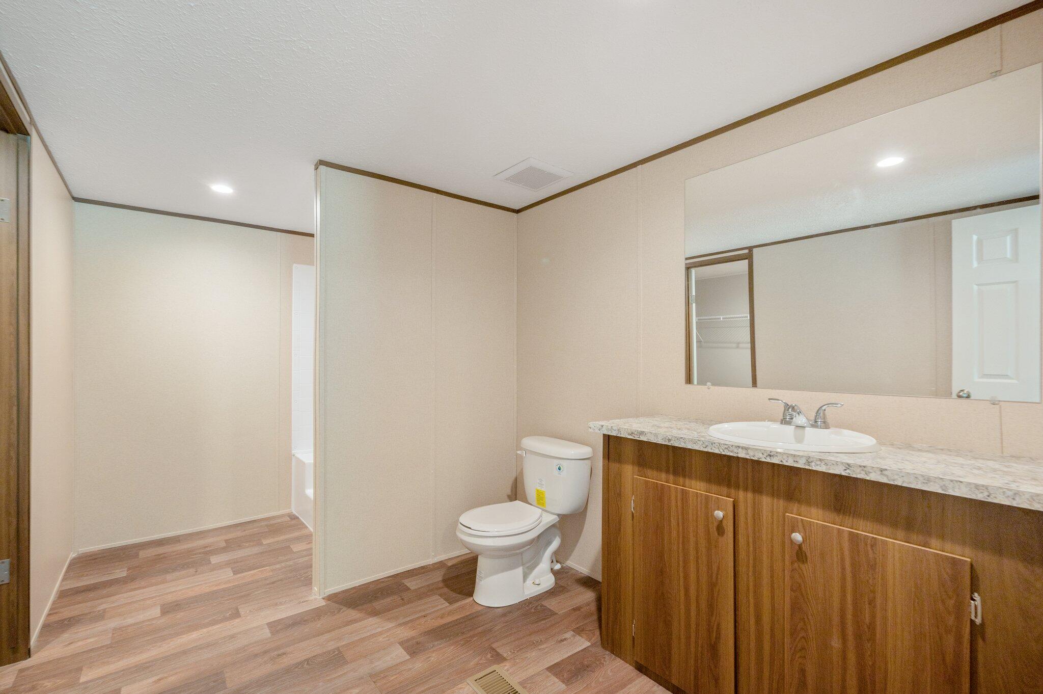 5227 Richardson Road Crestview, FL 32539 - Photo 21 of 44 a bathroom with a granite countertop sink a toilet a mirror and shower