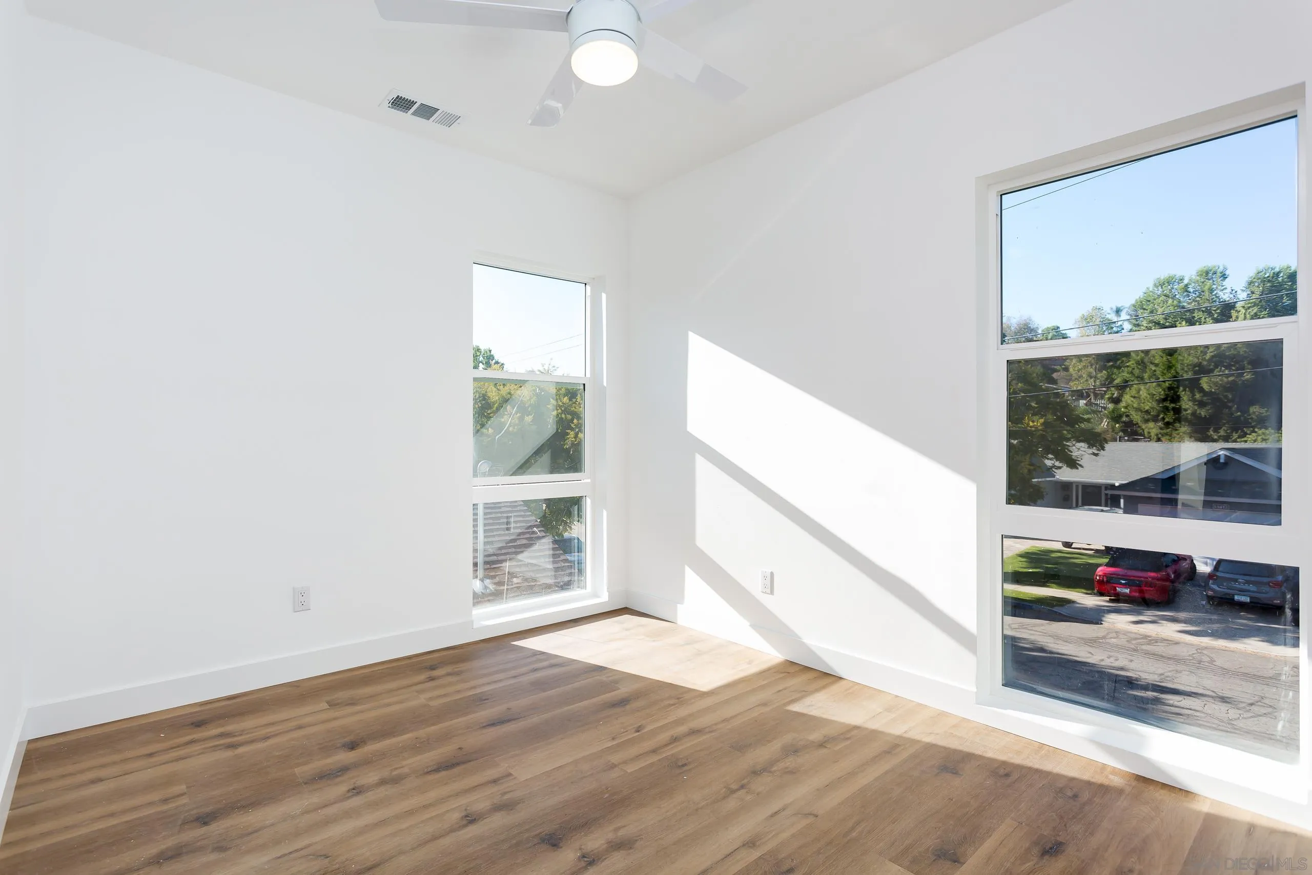 5721-23 Campanile Way San Diego, CA 92115 - Photo 18 of 59 an empty room with wooden floor and windows