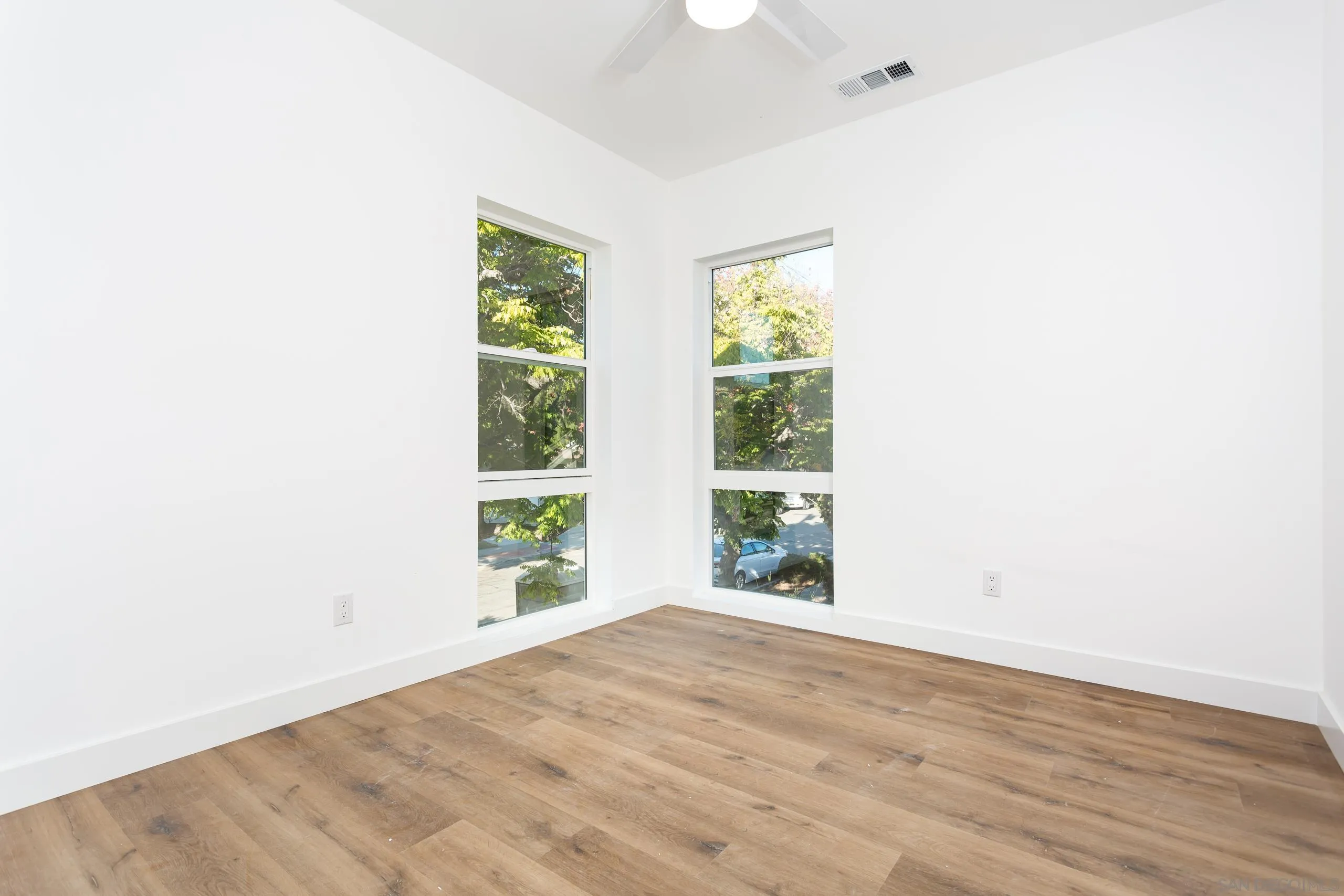 5721-23 Campanile Way San Diego, CA 92115 - Photo 20 of 59 a view of an empty room with wooden floor and a window