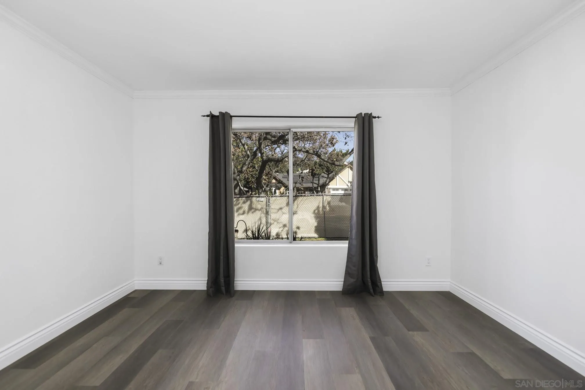5721-23 Campanile Way San Diego, CA 92115 - Photo 25 of 59 an empty room with wooden floor and window