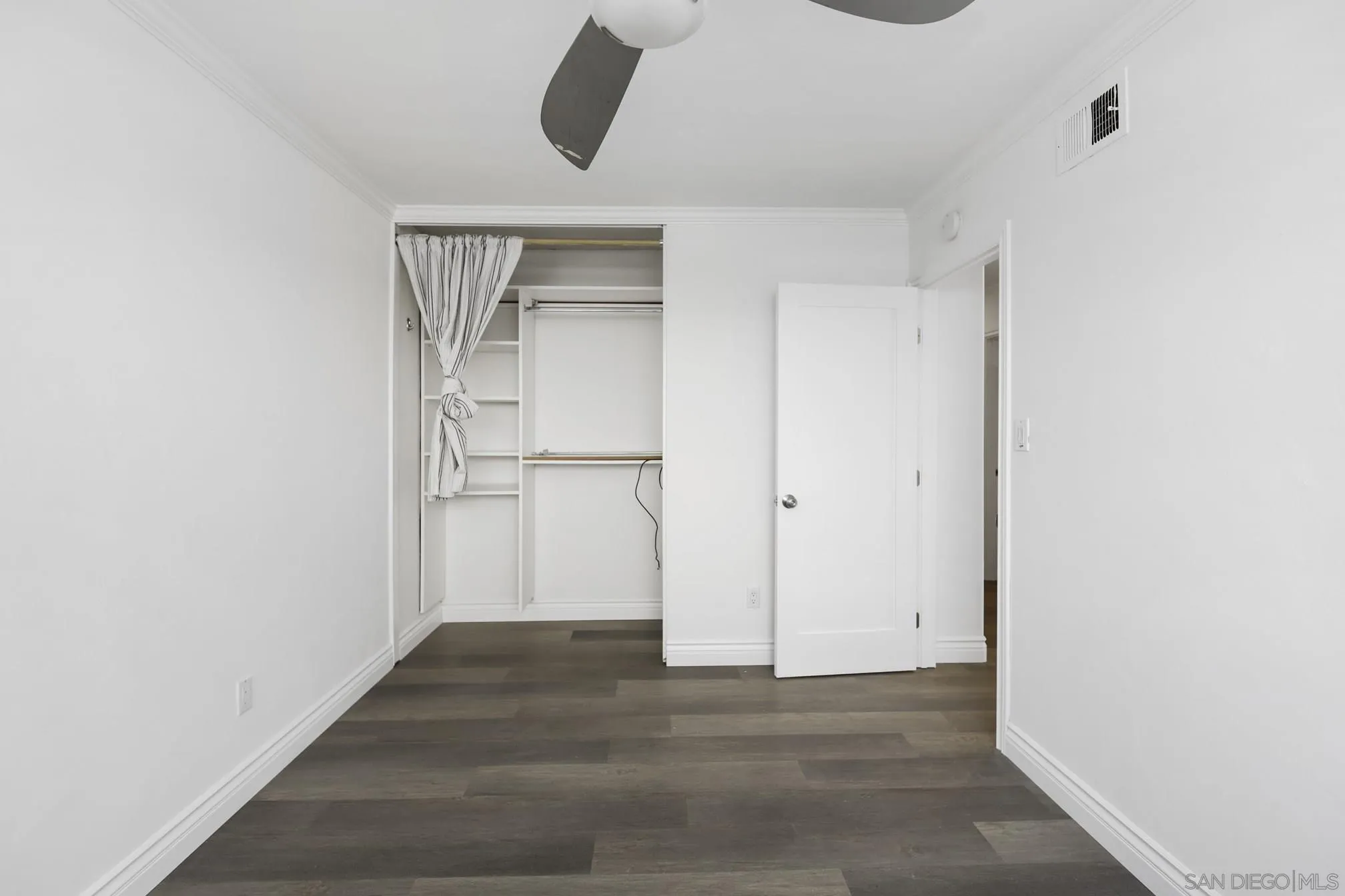 5721-23 Campanile Way San Diego, CA 92115 - Photo 29 of 59 a view of an empty room with wooden floor and closet