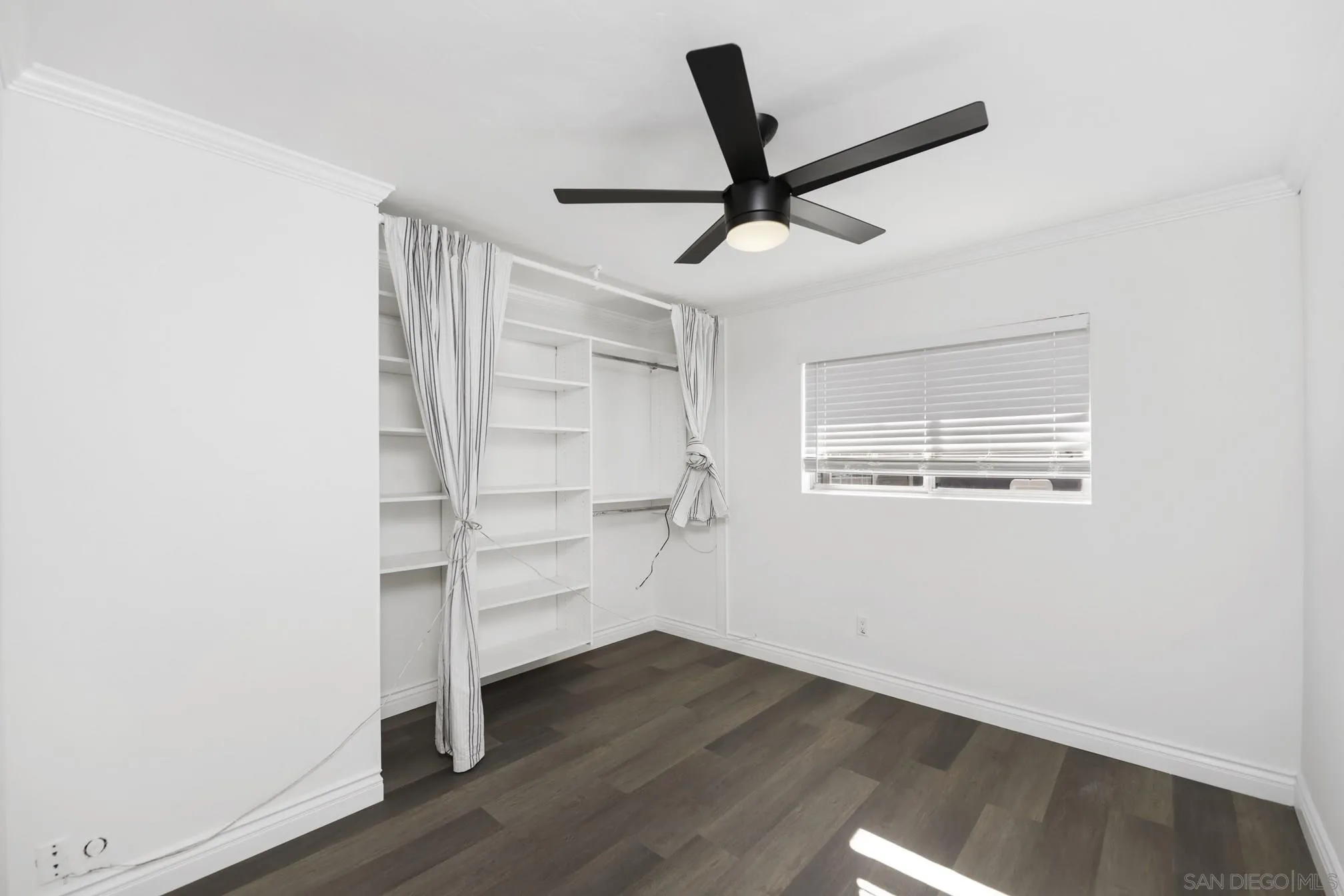 5721-23 Campanile Way San Diego, CA 92115 - Photo 36 of 59 a view of a livingroom with wooden floor and a ceiling fan