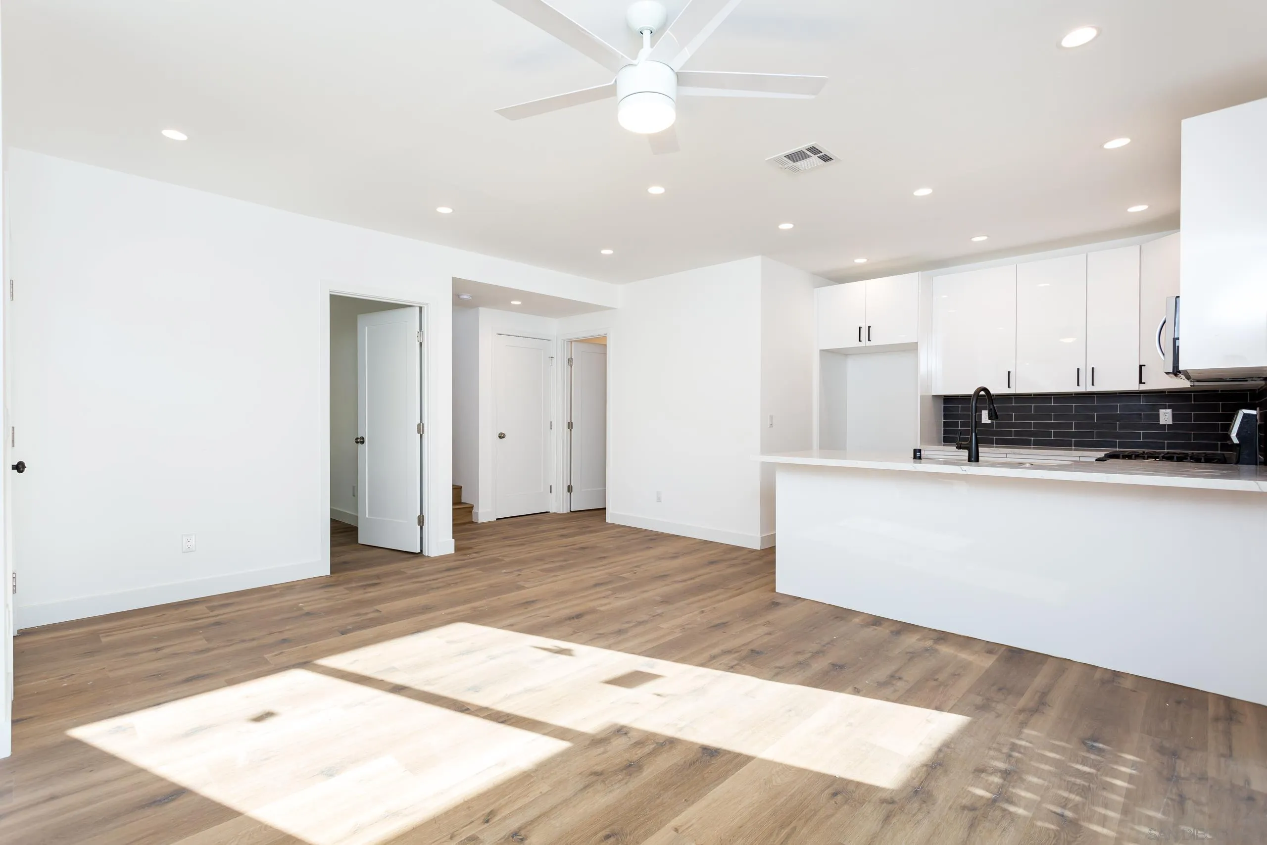 5721-23 Campanile Way San Diego, CA 92115 - Photo 4 of 59 a view of a kitchen with kitchen island a sink stainless steel appliances and cabinets