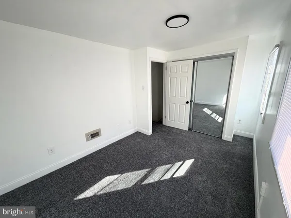 a view of empty room with wooden floor and ceiling fan