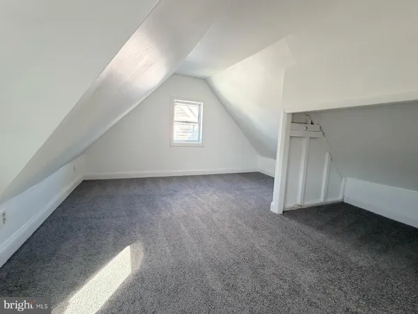an empty room with wooden floor and a ceiling fan