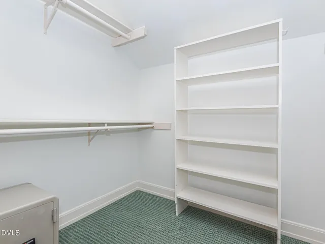 a view of walk in closet with empty racks