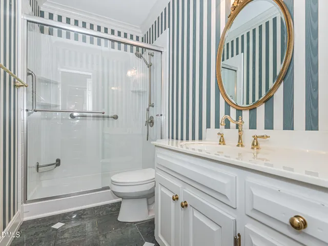 a bathroom with a granite countertop sink mirror vanity and toilet