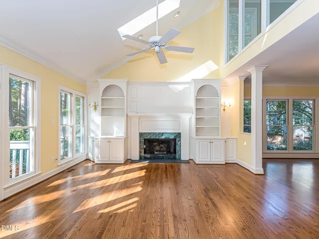 a view of empty room with wooden floor and fireplace