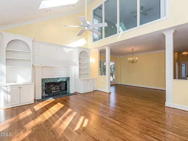 a view of empty room with wooden floor and fireplace