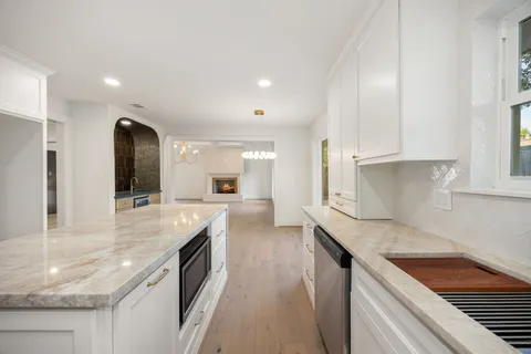 a kitchen with granite countertop white cabinets and a window