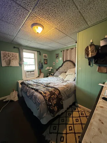 a bedroom with a bed and painting on the wall