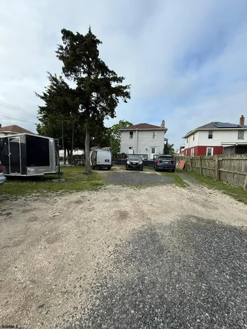 a view of a house with a yard and a car parked in front of it
