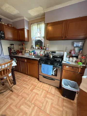 a kitchen with a sink a stove and cabinets