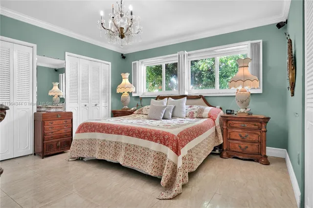 a spacious bedroom with a bed and a chandelier