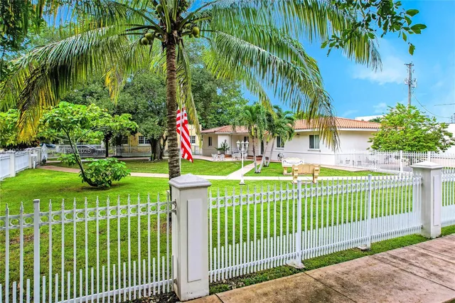 a front view of a house with a garden and plants