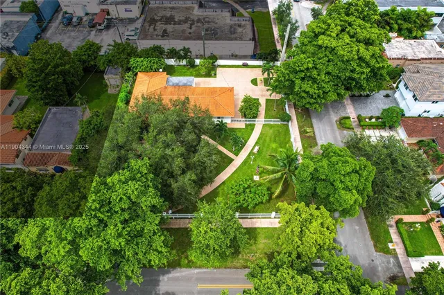 an aerial view of residential house with outdoor space and trees all around