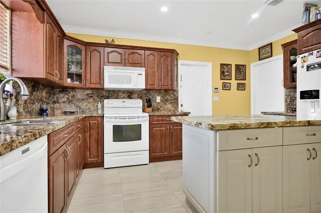 a kitchen with granite countertop a sink stove and cabinets
