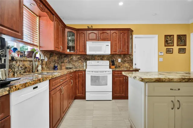a kitchen with stainless steel appliances granite countertop a stove a sink and a microwave