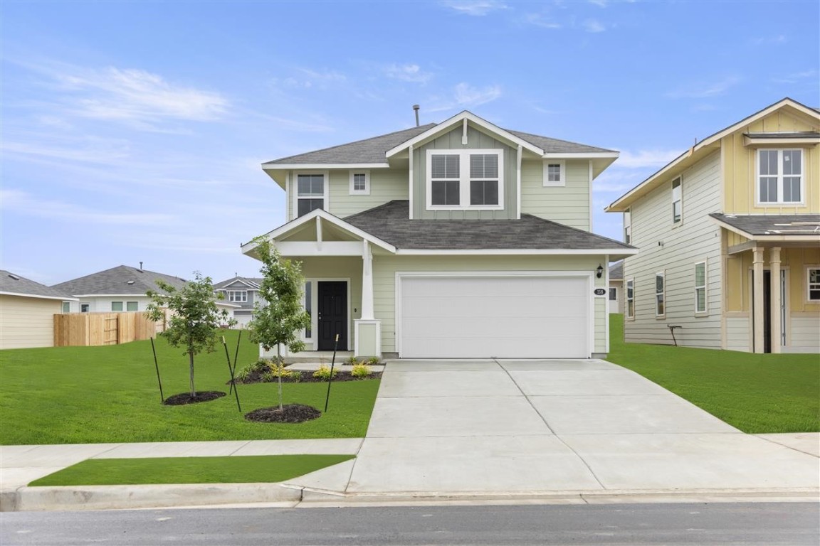 a front view of a house with a yard and trees