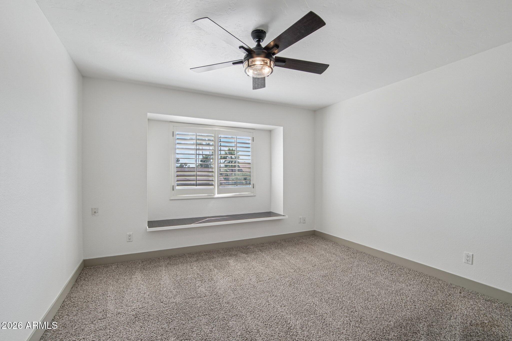 4662 East Grandview Road Phoenix, AZ 85032 - Photo 30 of 42 an empty room with a window and a ceiling fan