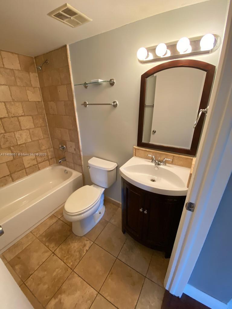 8830 Southwest 123rd Court, Unit I407 Miami, FL 33186 - Photo 11 of 18 a bathroom with a toilet sink and mirror