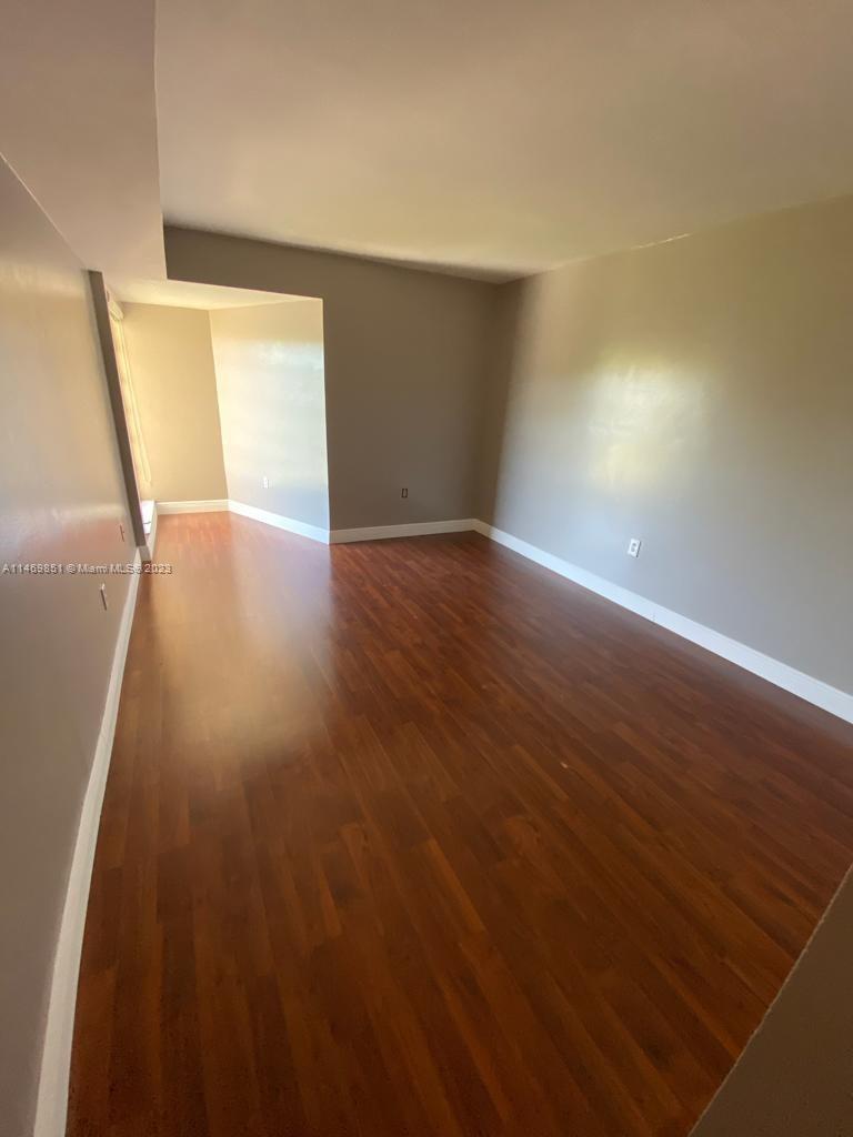 8830 Southwest 123rd Court, Unit I407 Miami, FL 33186 - Photo 12 of 18 a view of an empty room with wooden floor and a window