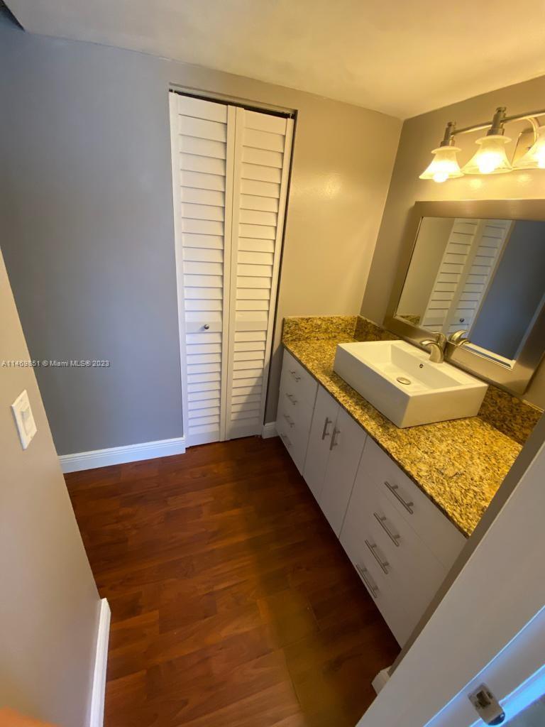 8830 Southwest 123rd Court, Unit I407 Miami, FL 33186 - Photo 14 of 18 a bathroom with a granite countertop sink and a mirror