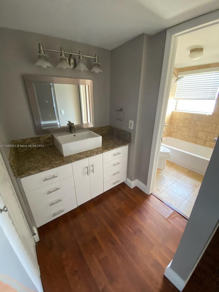 8830 Southwest 123rd Court, Unit I407 Miami, FL 33186 - Photo 15 of 18 a bathroom with a granite countertop sink and a mirror