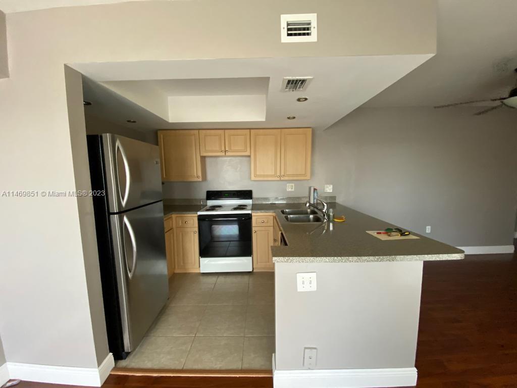 8830 Southwest 123rd Court, Unit I407 Miami, FL 33186 - Photo 6 of 18 a kitchen with stainless steel appliances granite countertop a refrigerator a stove a sink and a microwave