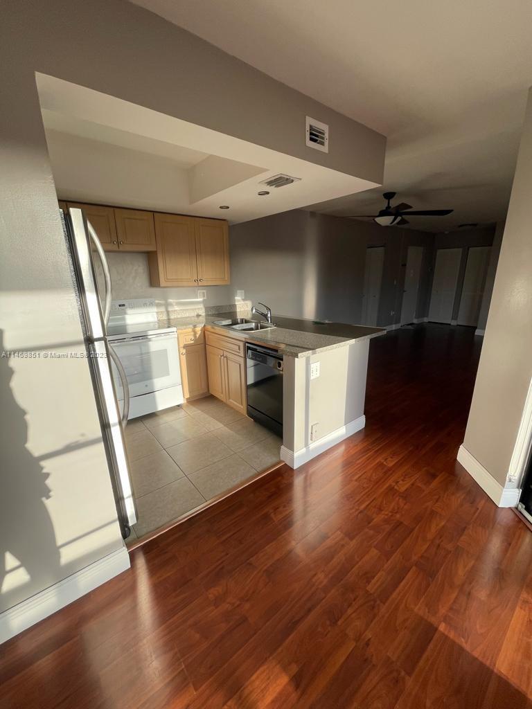 8830 Southwest 123rd Court, Unit I407 Miami, FL 33186 - Photo 7 of 18 a view of a kitchen with a sink and a refrigerator