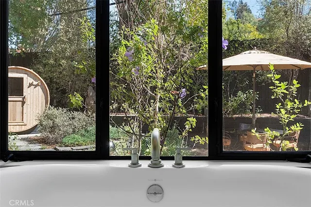 a bedroom with a bed wooden floor and potted plant