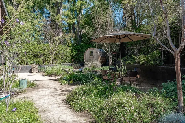 a backyard of a house with table and chairs under an umbrella