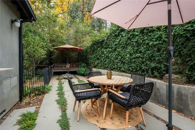 a view of a patio with table and chairs potted plants and tree