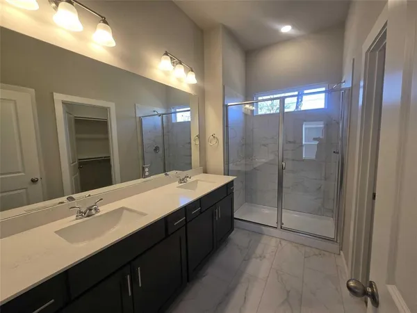a bathroom with a double vanity sink mirror and shower