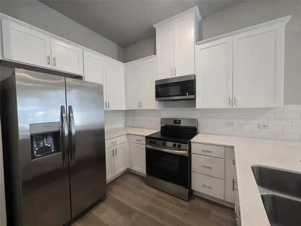 a kitchen with stainless steel appliances a refrigerator stove and microwave