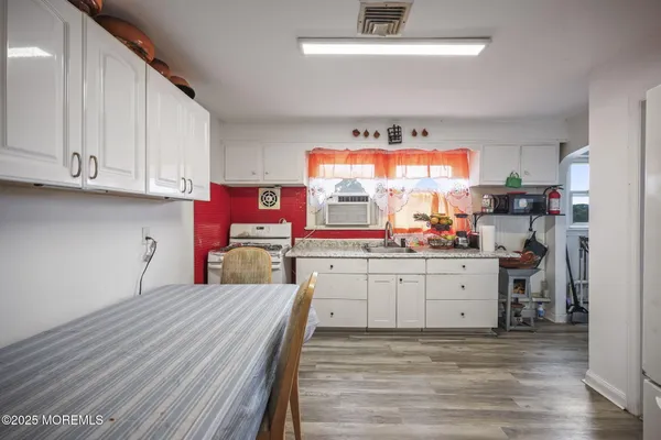 a kitchen with granite countertop a dining table chairs and a refrigerator