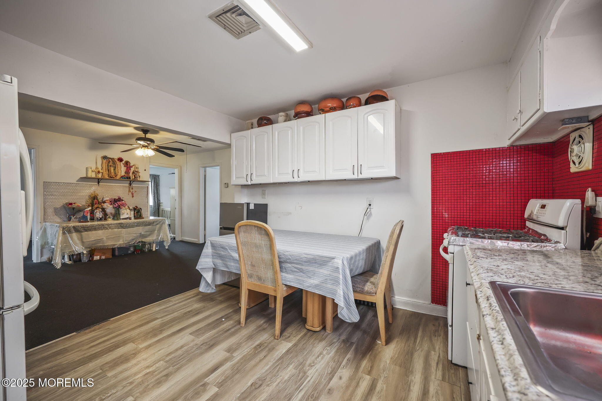 Herbertsville Road Brick, NJ 08724 - Photo 18 of 35 a kitchen with granite countertop a dining table chairs and a refrigerator