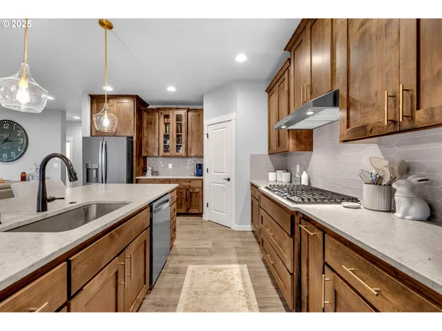 a kitchen with kitchen island granite countertop a sink stainless steel appliances and cabinets