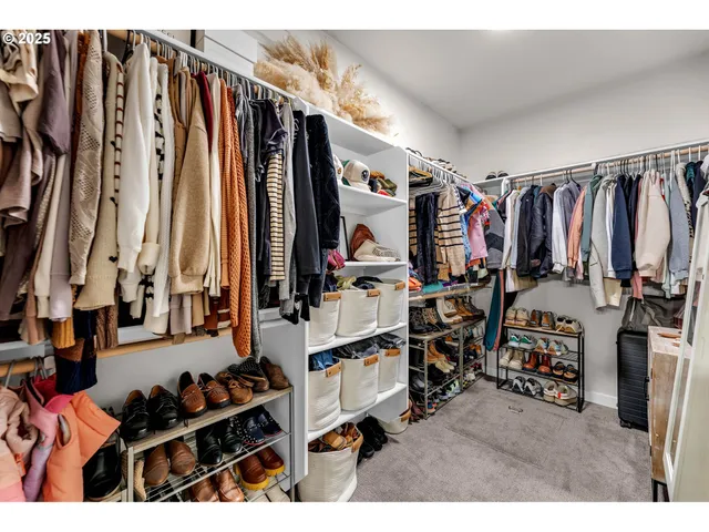 a view of walk in closet with clothes and shoes