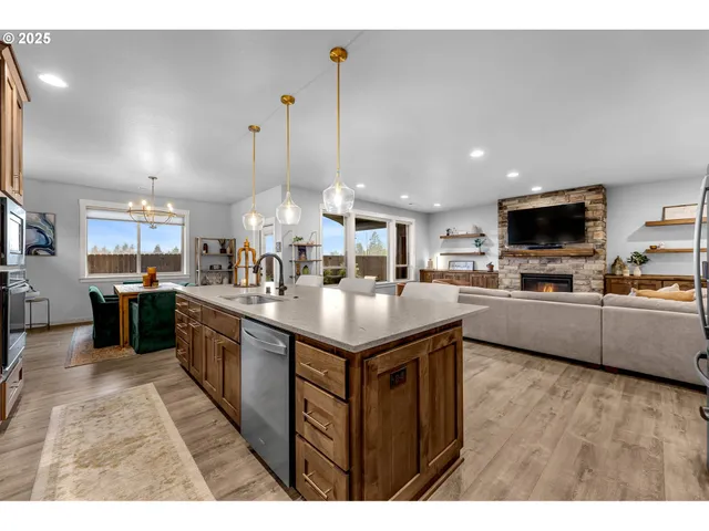 a kitchen with stainless steel appliances granite countertop a sink a stove and a wooden floors