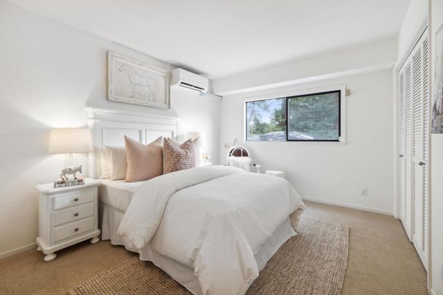 a bedroom with bed and paintings on the wall